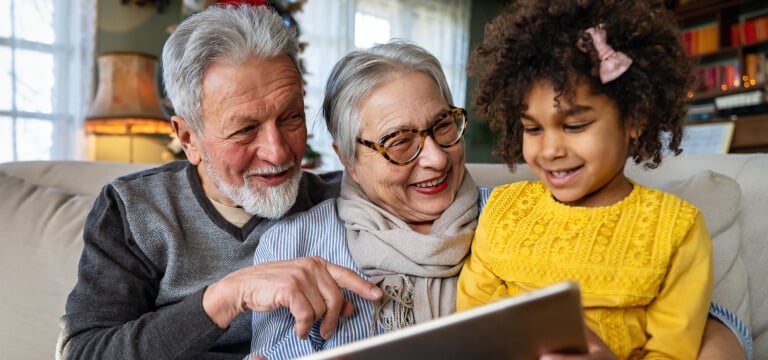 Grandparents and grandchild reading books on the sofa