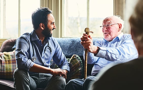 older and younger man sat together on sofa