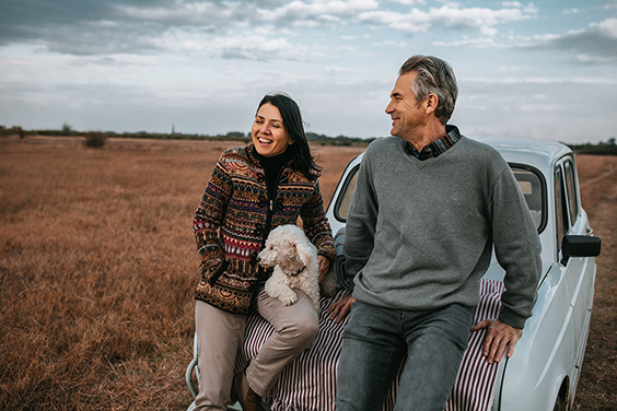 couple enjoying view from their car with their dog