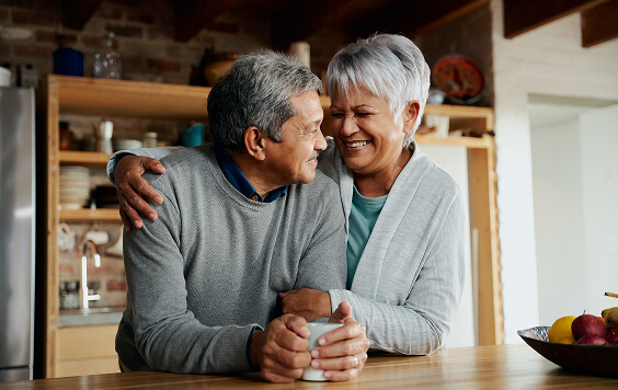 Older couple smiling together inside their house