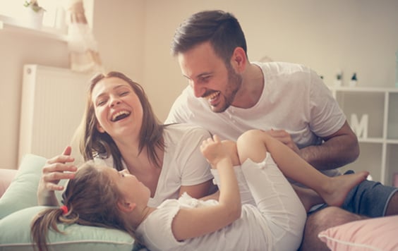Man and women laughing with their child