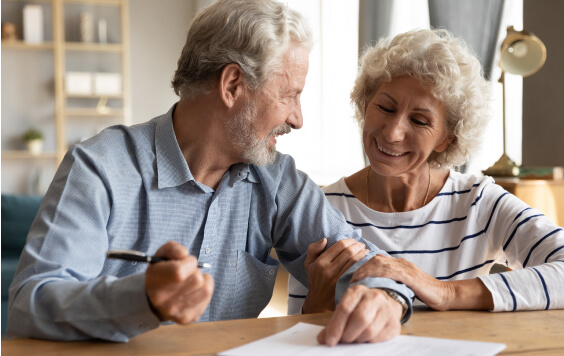 an older couple signing a document (Will)