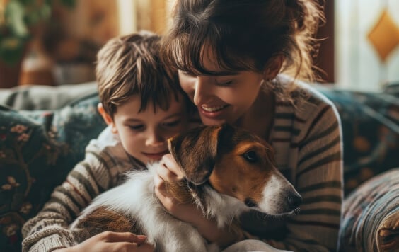 Happy mother and son at home petting their dog