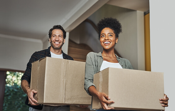 Happy-couple-moving-home-carrying-boxes564x356
