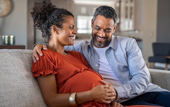 Pregnant woman with her partner on the sofa