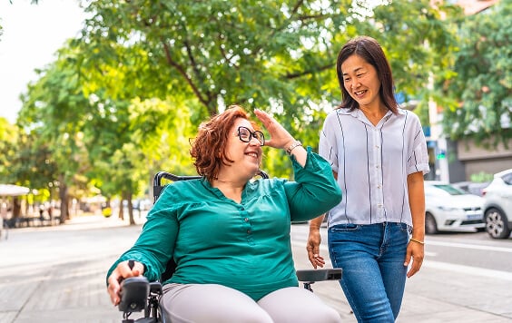 Woman in a wheelchair with her friend outside