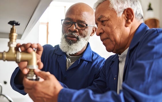 Plumbers Fixing Pipes and Building Bonds with Elderly Clients