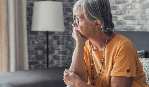 Sad, female pensioner looking out of a window