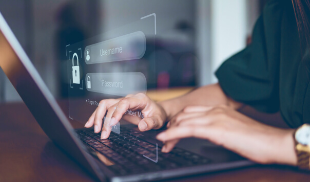 Female hands typing a password into a site on a laptop