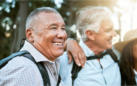Excited older male hiker with his senior friends outdoors.