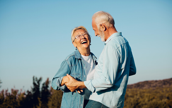 Older couple laughing together outside