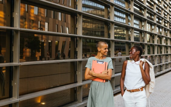 Joyful Co-workers Walking in Front of Business Building