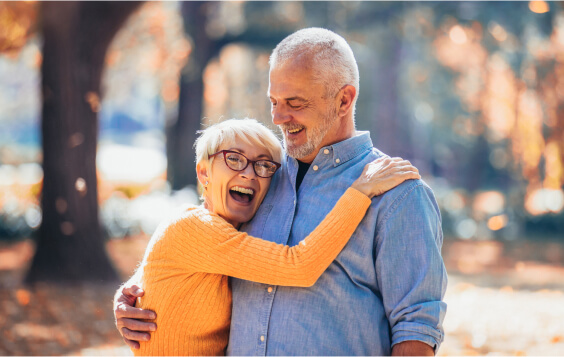 Older couple hugging outside