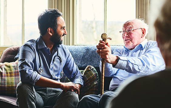 older and younger man sat together on sofa