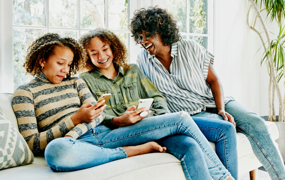 A mother and her two teenage daughters on a sofa