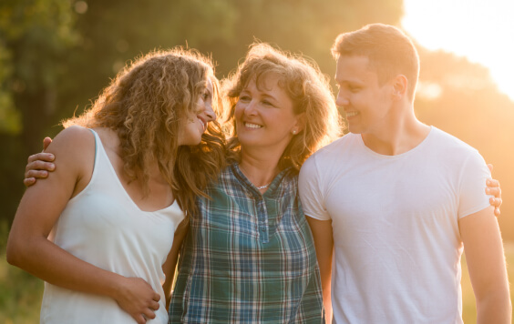 Family smiling with the sunset in the background