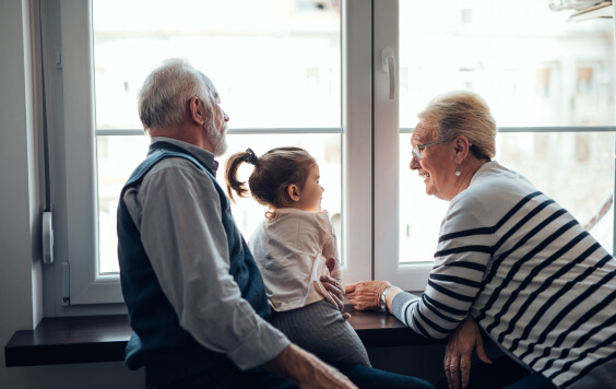 Grandparents sitting with their granddaughter