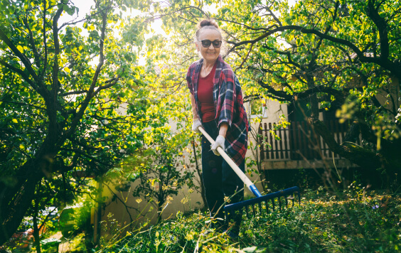 Lady in her garden with a rake