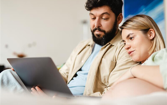 Man and pregnant lady looking at a laptop