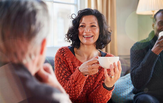 Lady drinking from a mug inside her home
