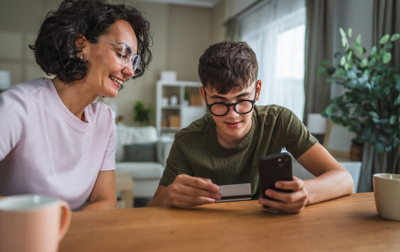 Mother and son looking at a card and phone