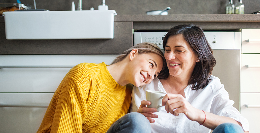 mum in white shirt and daughter yellow jumper sitting on the floor