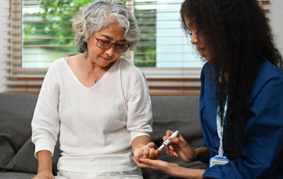 A nurse checking a woman's blood sugar levels