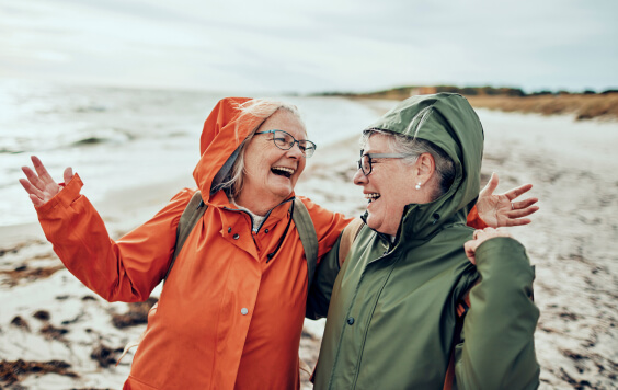 Smiling senior female couple walking on a beach