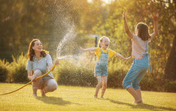 Family playing outside in water