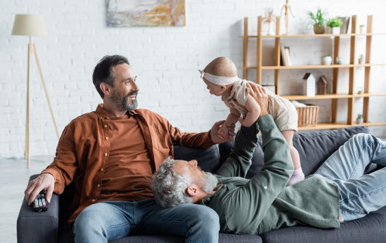 two-men-playing-with-baby-on-a-sofa