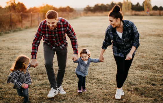 Family holding hands in field