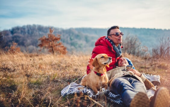 Sam sex couple sat on a blanket at the top of a hill