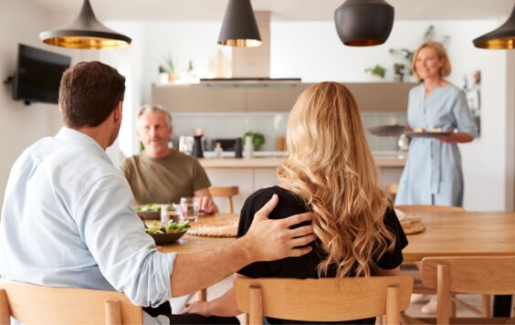 Family With Senior Parents And Adult Offspring Eating Meal Around Table At Home Together