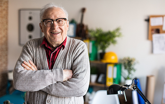 older man with glass and cardigan on