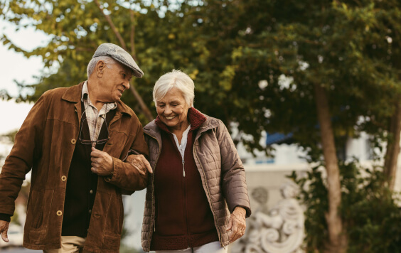 Happy retired couple walking outdoors on winter day 