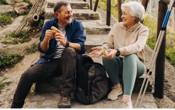 An older couple sitting outside smiling