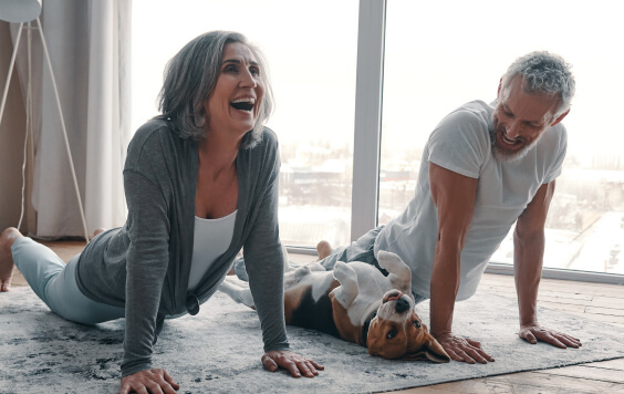 A couple doing yoga with their dog