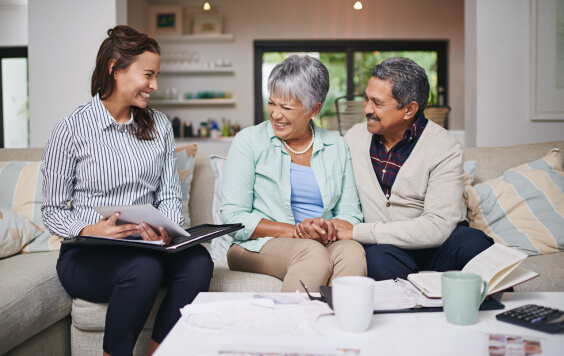 Older couple talking with a professional on a sofa
