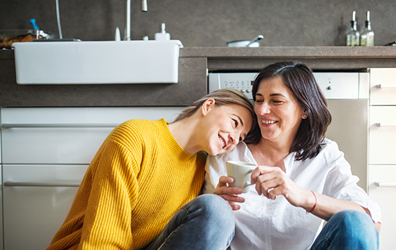 mum in white shirt and daughter yellow jumper sitting on the floor