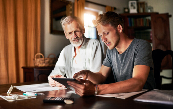 Son showing father something on an iPad