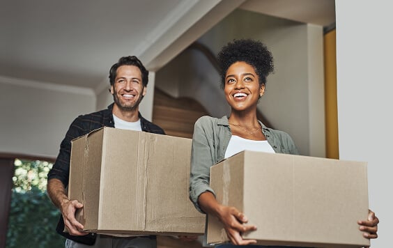Happy-couple-moving-home-carrying-boxes564x356