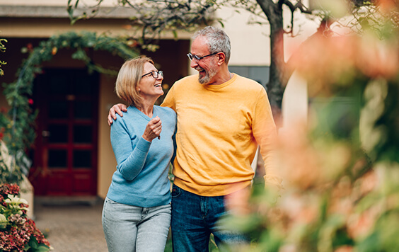Older couple walking together smiling at each other
