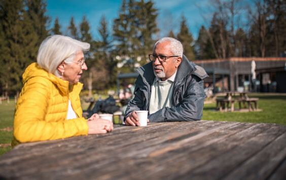Older couple drinking outside on a bench