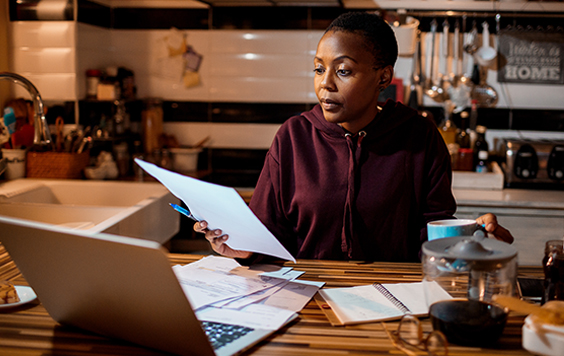 Lady working on laptop with paperwork
