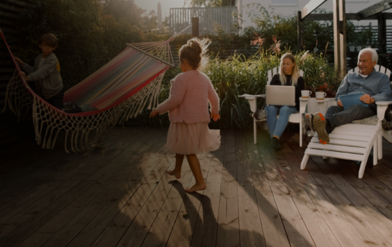 family in garden with little boy playing on a hammock