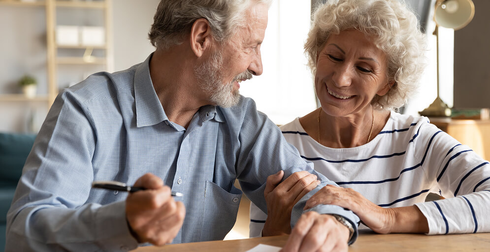 an older couple signing a document (Will)