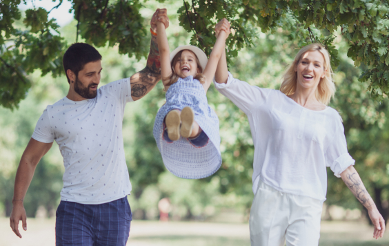 Parents swinging their daughter in the air