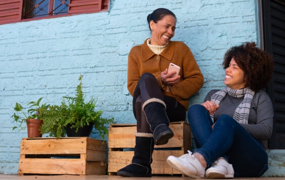 Female couple laughing outside