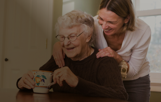 daughter leaning over mother shoulder laughing
