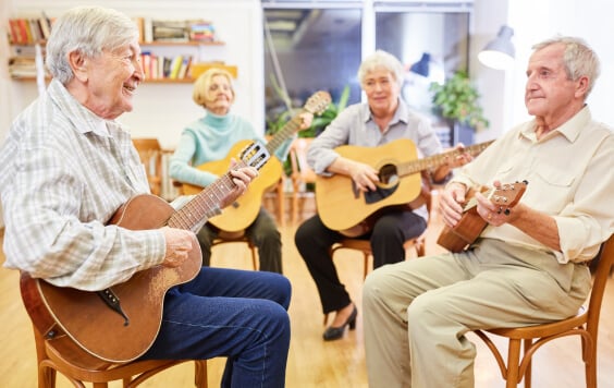A group of retirement age people playing acoustic guitar
